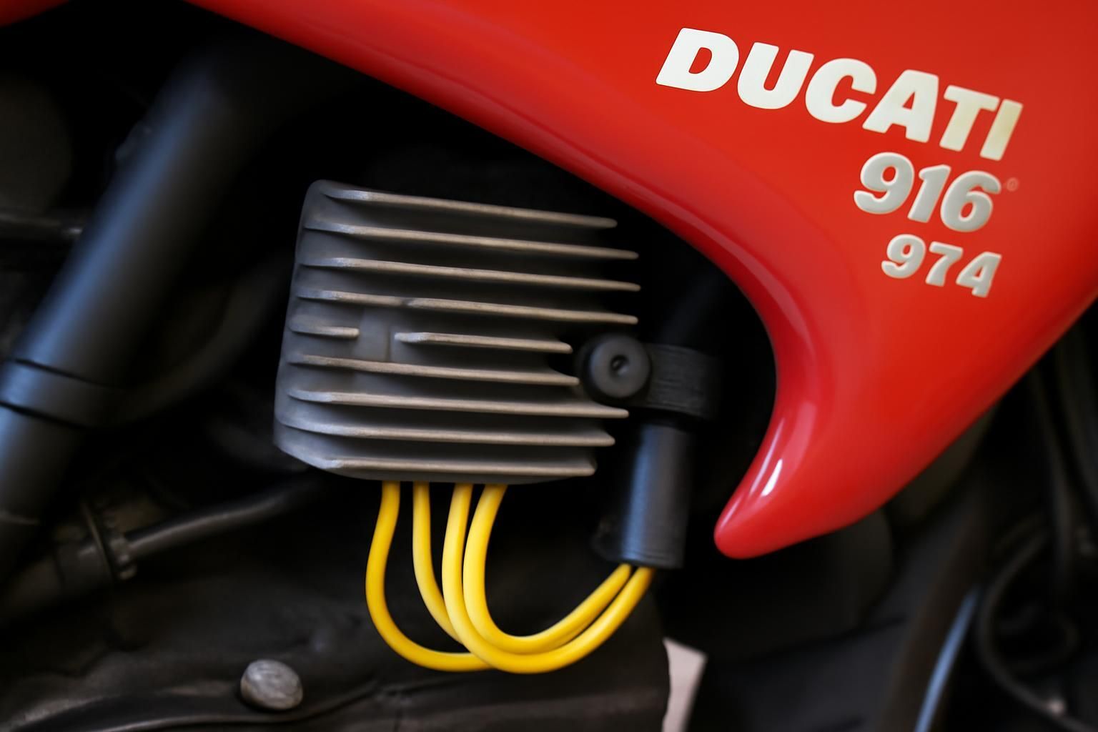 Découvrez où se trouve le régulateur de tension sur une Ducati 916 ST4 de l'année 2000 et apprenez à le localiser facilement pour l'entretien ou le remplacement.